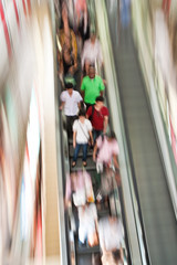 Menschen auf einer Rolltreppe in Gruppe in Bewegung