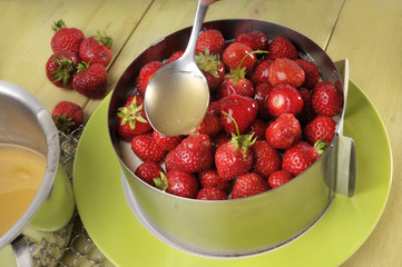 Tortenguss über Erdbeeren verteilen