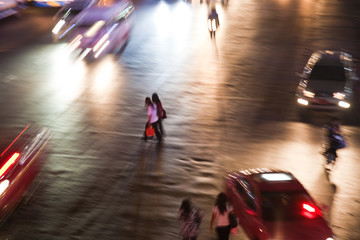 Frauen überqueren bei starkem Autoverkehr und nacht eine Strasse