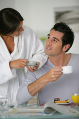 Homme et femme se regardant en prenant leur petit déjeuner