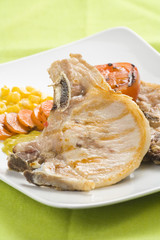 tasty pork chop with corn carrot tomato