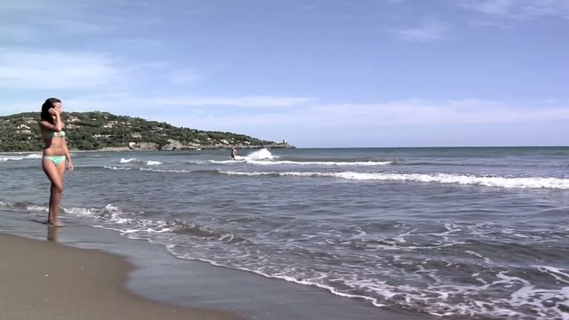 ragazza in bikini passeggia al mare
