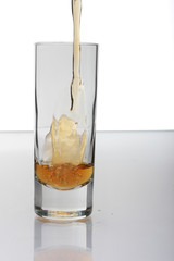Shot of Liquor Being Poured into Tall Round Glass