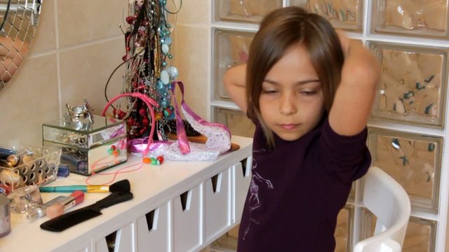 fillette se coiffant dans la salle de bain