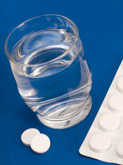 Glas Wasser mit Medikament