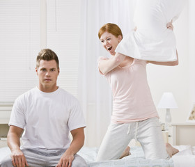 Fototapeta premium Attractive Couple Playing Around with a Pillow Fight