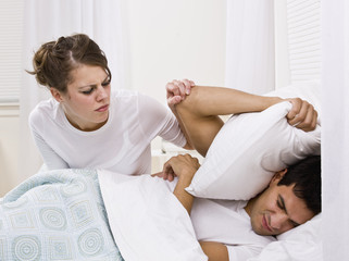 Fototapeta na wymiar Wife Trying to Wake Up her Husband