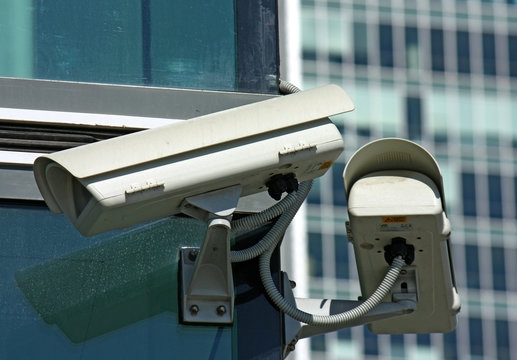 two surveillance cameras and glass