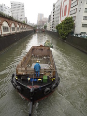 Barcaza llevando basura por el canal en Tokio