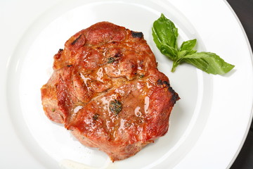 Grilled pork chop on a white plate