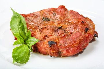 Grilled pork chop on a white plate