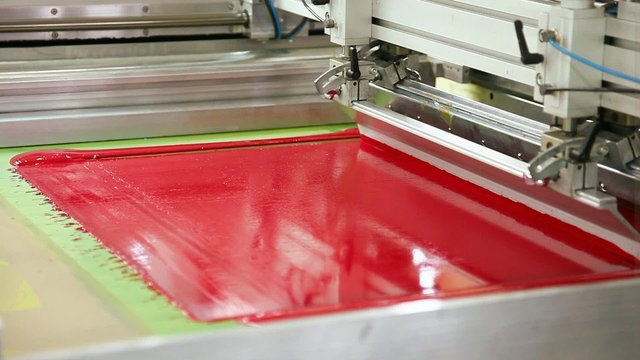 Screen printing machine working, printing magenta