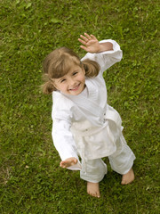 Little girl exercising in garden