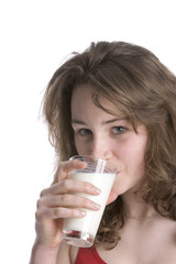 Teenage girl is drinking a glass of milk