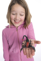 Little girl with a plastic scorpion