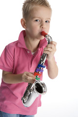 Little boy is playing a toy saxophone