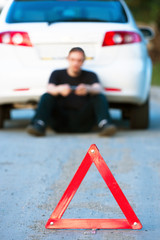 Car accident on a road. Focus is on the red triangle sign