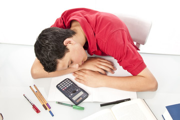 Schüler schläft erschöft am Schreibtisch