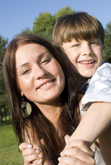 Obraz premium Mother and son having fun in a meadow