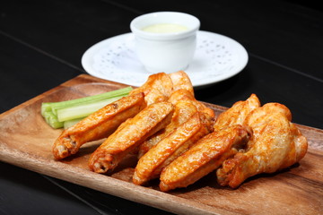 Grilled chicken wings served on wooden board