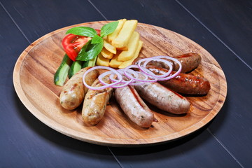Assortment of grilled sausages on the wooden plate