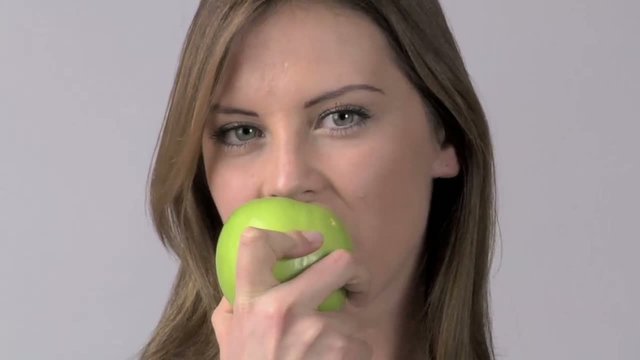 ragazza morde mela verde