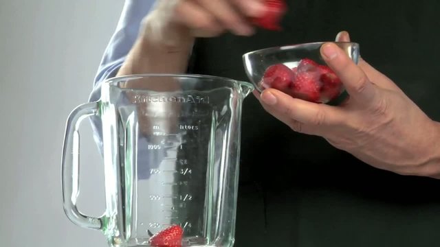 Uomo prepara frullato di fragole