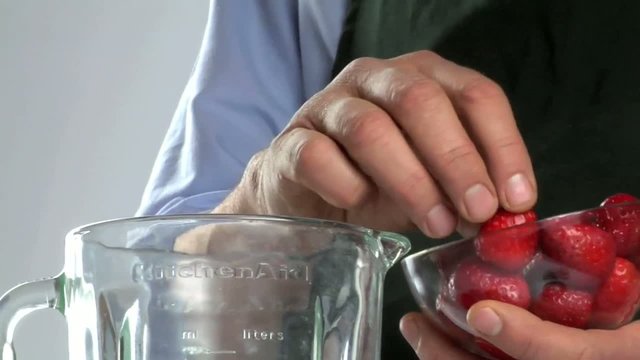Mani mettono fragole nel frullatore