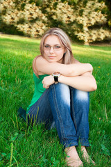 Fototapeta premium Young beautiful woman portrait on grass background