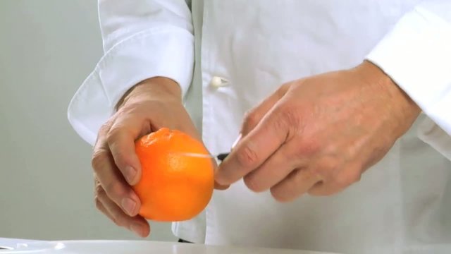 Cuoco sbuccia un arancio