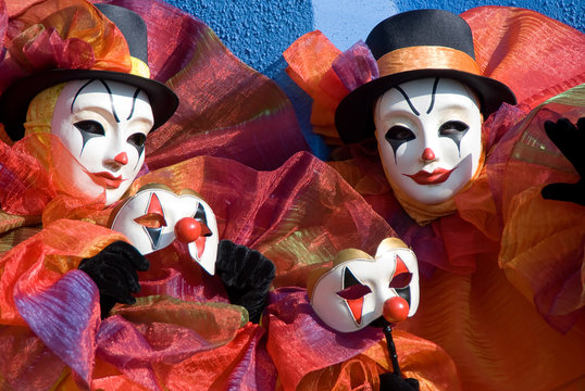 Two clowns with mask in the hands