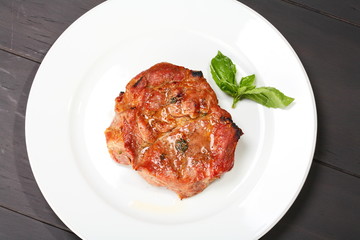 Grilled pork chop on a white plate