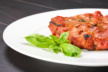 Grilled pork chop on a white plate