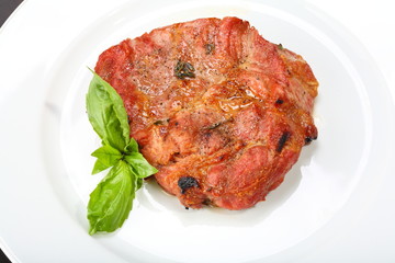 Grilled pork chop on a white plate