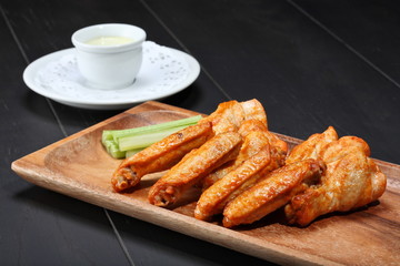 Grilled chicken wings served on wooden board
