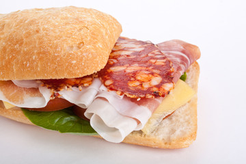 Ciabatta sandwich stuffed with sliced delicacies