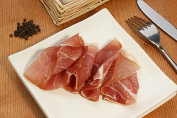 geräucherte Schinkenscheiben auf einem weißen Teller