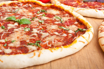 group of three different pizzas on wooden table