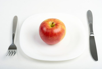 Utensils and red apple