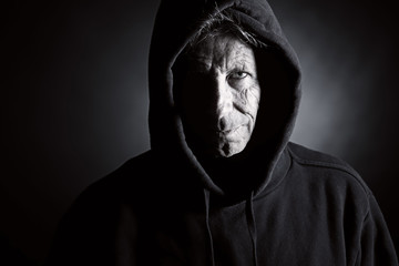 Low Key Shot of an Intimidating Senior Male in Hooded Top