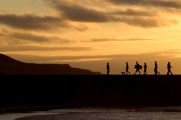 Fototapeta na wymiar Silhouette of people walking at sunset