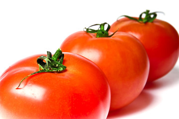 three ripe tomatoes on a white background