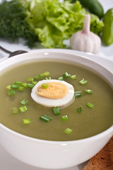 serving of spinach cream soup with vegetables at the back