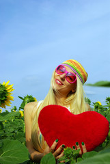 Beautiful blonde in pink glasses with heart in hands