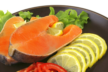 two salmon steak on dark dish