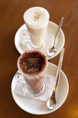 Hot chocolate in a tall class with Cafe Latte on a table