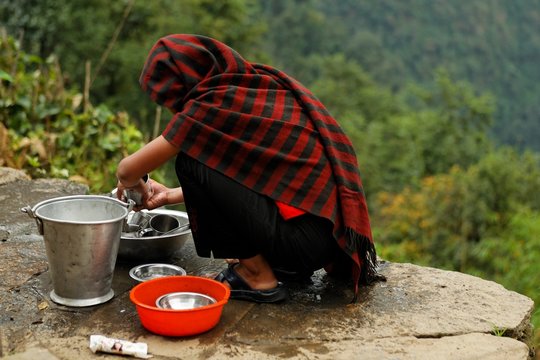 Femme traditionelle faisant la vaisselle
