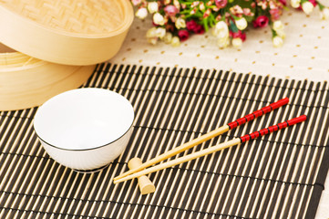 Chopsticks and bowl on the bamboo mat