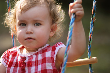 Small girl on a wooden Swing