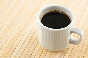 Coffee cup on a bamboo mat.